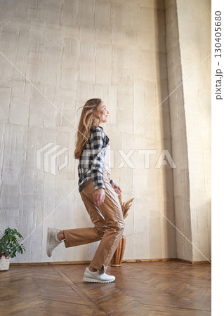 Caucasian female adult in casual outfit walking indoors with natural light 130405680