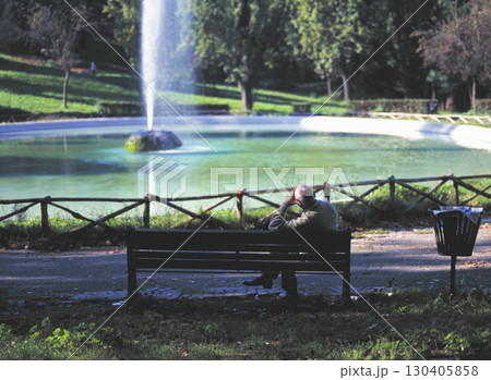 ローマ市内の町並み ボルゲーゼ公園 噴水周りのベンチでくつろぐ男性 130405858