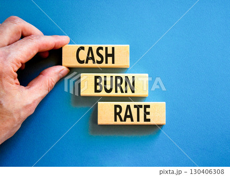 Cash burn rate symbol. Concept words Cash burn rate on wooden blocks on a beautiful blue table blue background. Businessman hand. Business cash burn rate concept. Copy space. 130406308