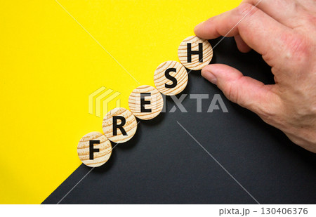 Fresh symbol. Concept word Fresh on beautiful wooden circles. Beautiful yellow and black background. Businessman hand. Business lifestyle fresh concept. Copy space. 130406376
