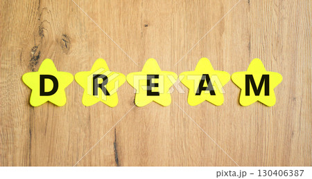 Dream symbol. Concept word Dream on beautiful yellow paper stars. Beautiful wooden table wooden background. Business lifestyle dream concept. Copy space. Dream symbol. Concept word Dream on beautiful yellow paper stars. Beautiful wooden table wooden background. Business lifestyle dream concept. Copy space. 130406387
