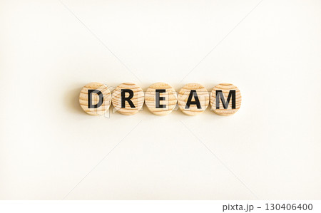 Dream symbol. Concept word Dream on beautiful wooden circles. Beautiful white table white background. Business lifestyle dream concept. Copy space. Dream symbol. Concept word Dream on beautiful wooden circles. Beautiful white table white background. Business lifestyle dream concept. Copy space. 130406400