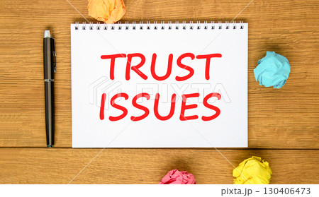 Trust issues symbol. Concept word Trust issues on beautiful white note. Black pen, colored paper. Beautiful wooden background. Business trust issues concept. Copy space. 130406473