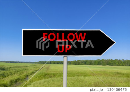 Follow up symbol. Concept word Follow up on beautiful black road sign. Beautiful green grass field blue sky background. Business follow up concept. Copy space. 130406476