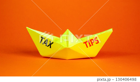 Tax tips symbol. Concept word Tax tips on beautiful yellow paper boat. Beautiful orange paper background. Business tax tips concept. Copy space. 130406498