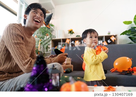Halloween Family Fun. A joyful father and son enjoying Halloween decorations and activities at home. Halloween Family Fun. A joyful father and son enjoying Halloween decorations and activities at home. 130407169