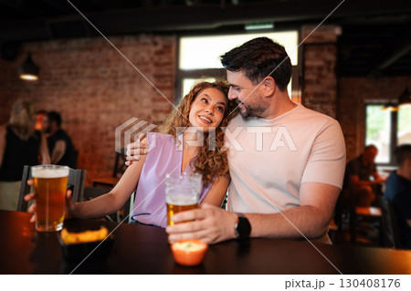 Couple enjoying a romantic evening drinking beer at the pub Couple enjoying a romantic evening drinking beer at the pub 130408176