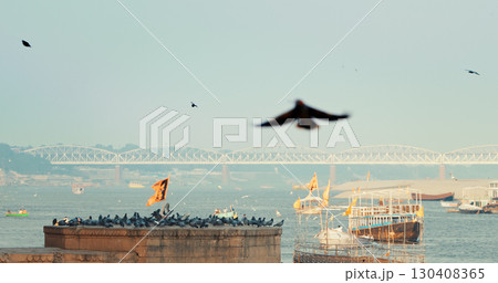 Varanasi, India. Bird Take Off from Sacred Ghat In Varanasi. Pigeons Fly Up In Slow Mo. Birds Flight. Orange Flags Fluttering In Slow Mo, Symbolizing Hanuman. Cinematic View On Ganga River. Many 130408365