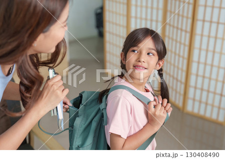 Child smiling while getting ready for school with backpack 130408490
