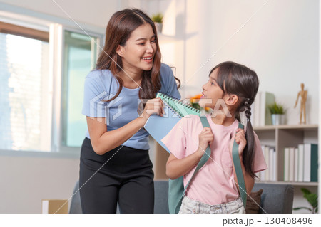 Child and Education. A mother and daughter sharing smiles while preparing for school. Child and Education. A mother and daughter sharing smiles while preparing for school. 130408496