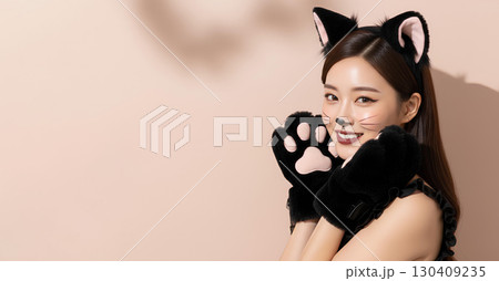ハロウィンの猫コスプレの若い女性が笑顔でポーズを決める 130409235