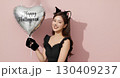ハロウィンの猫コスプレの若い女性が笑顔でポーズを決める 130409237