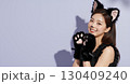 ハロウィンの猫コスプレの若い女性が笑顔でポーズを決める 130409240