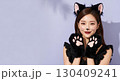 ハロウィンの猫コスプレの若い女性が笑顔でポーズを決める 130409241