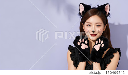 ハロウィンの猫コスプレの若い女性が笑顔でポーズを決める 130409241