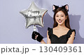 ハロウィンの猫コスプレの若い女性が笑顔でポーズを決める 130409361