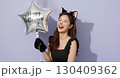 ハロウィンの猫コスプレの若い女性が笑顔でポーズを決める 130409362