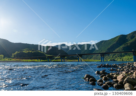 夕日に照らされた四万十川と佐田沈下橋 夕日に照らされた四万十川と佐田沈下橋 130409606