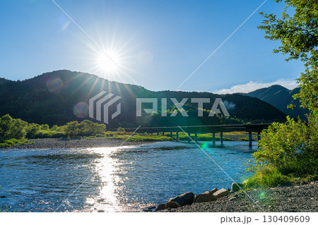 夕日に照らされた四万十川と佐田沈下橋 夕日に照らされた四万十川と佐田沈下橋 130409609