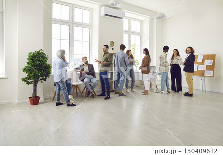 Company employees talking after a meeting in the office discussing job and work projects. Company employees talking after a meeting in the office discussing job and work projects. 130409612