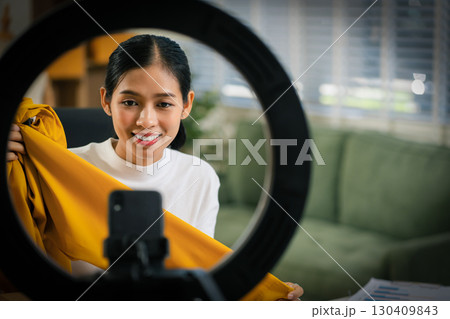 Asia vlogger woman influencer, SME retail store owner smile enjoy selling show live sale online screen smartphone and laptop work at home. Asia vlogger woman influencer, SME retail store owner smile enjoy selling show live sale online screen smartphone and laptop work at home. 130409843