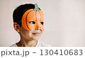 Child in a pumpkin halloween mask on a neutral background 130410683