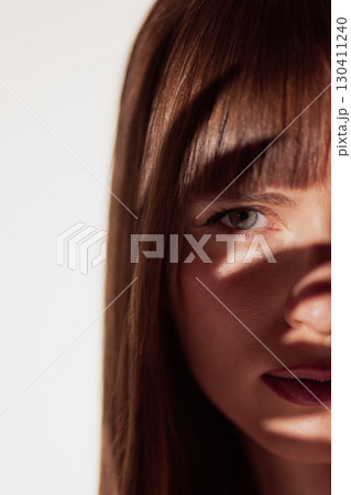 Half face female portrait with shadow across eye in minimal clean style Half face female portrait with shadow across eye in minimal clean style 130411240