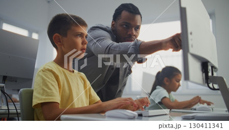 Smart Young Boy Using Computer, Doing 3D Design Project. Teacher Helping Elementary School Student 130411341