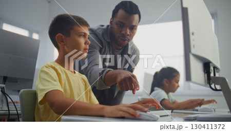 Smart Young Boy Using Computer, Doing 3D Design Project. Teacher Helping Elementary School Student Smart Young Boy Using Computer, Doing 3D Design Project. Teacher Helping Elementary School Student 130411372