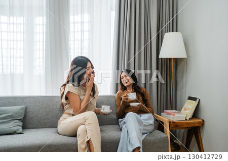 A Group of Joyful Friends Enjoying Tea Together in a Cozy Living Room Setting 130412729