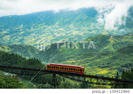 Red mountain train crossing a bridge in misty Sapa, Vietnam Red mountain train crossing a bridge in misty Sapa, Vietnam 130412960
