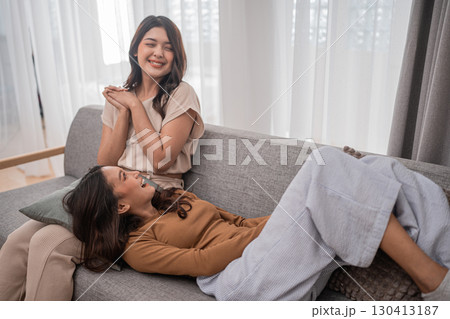 Sharing Joyful Moments of True Friendship Two Women Happily Laughing Together on a Couch 130413187