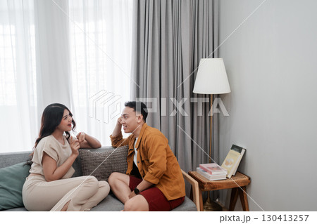 A Young Couple Happily Engaging in a Relaxed and Casual Conversation at Home 130413257