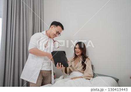 Medical Consultation Doctor Discusses Health with Patient Resting in Bed 130413443