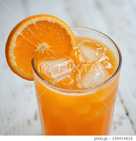A glass of orange juice with ice cubes and orange slice garnish, suitable for warm weather, gathering or as daily refreshment.	 130414818