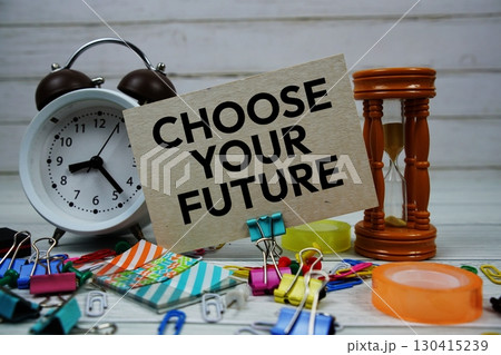 Choose Your Future text on paper card with alarm clock and stationary on wooden background Choose Your Future text on paper card with alarm clock and stationary on wooden background 130415239