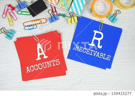 AR - Accounts Receivable text on stick note with stationery on concrete background AR - Accounts Receivable text on stick note with stationery on concrete background 130415277