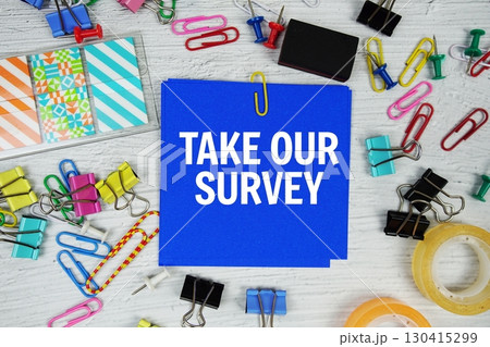 Take Our Survey text on stick note with stationery on concrete background 130415299