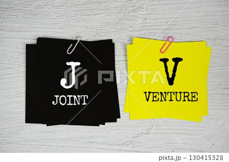 JV - Joint Venture text on stick note on concrete background 130415328
