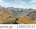 Breathtaking views of Lago Bianco reservoir at the Bernina Pass in Graubunden. Towering mountains and glaciers create a stunning alpine landscape under a clear sky. 130415515
