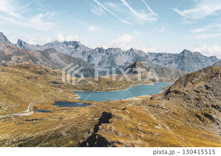 Breathtaking views of Lago Bianco reservoir at the Bernina Pass in Graubunden. Towering mountains and glaciers create a stunning alpine landscape under a clear sky. 130415515