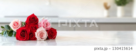 Beautiful bouquet of fresh pink and red roses lying on a modern white marble kitchen countertop, perfect for celebrating valentine's day, mother's day, or women's day 130415614