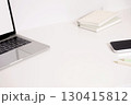 Laptop, phone, color pencils and notebook scattered on desk 130415812