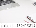 spiral notebook and pink color pencil and keypad laptop on a white desk surface 130415813