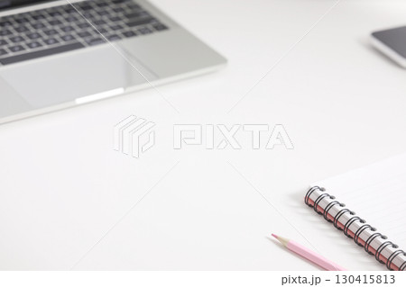 spiral notebook and pink color pencil and keypad laptop on a white desk surface spiral notebook and pink color pencil and keypad laptop on a white desk surface 130415813