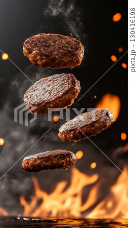 Four perfectly seared hamburger patties levitating over a flaming grill, creating a dynamic and mouthwatering culinary scene with a dark background 130416198