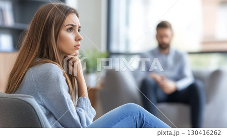 Pensive patient is receiving psychological support during individual therapy session with a professional counselor in a bright office, focusing on mental health and emotional wellbeing 130416262