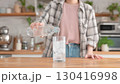 グラスに水を注ぐ女性 130416998