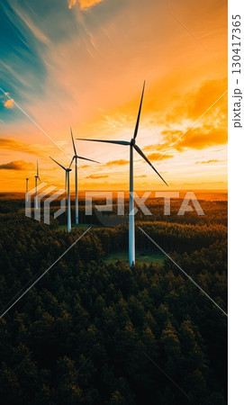 Wind turbines are generating clean energy at sunset over a forest, symbolizing sustainable power and eco friendly practices for a greener future 130417365