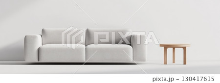 White sofa and small wooden coffee table standing in an empty room with white walls and floor, creating a minimalist and modern interior design perfect for showcasing furniture or other products 130417615
